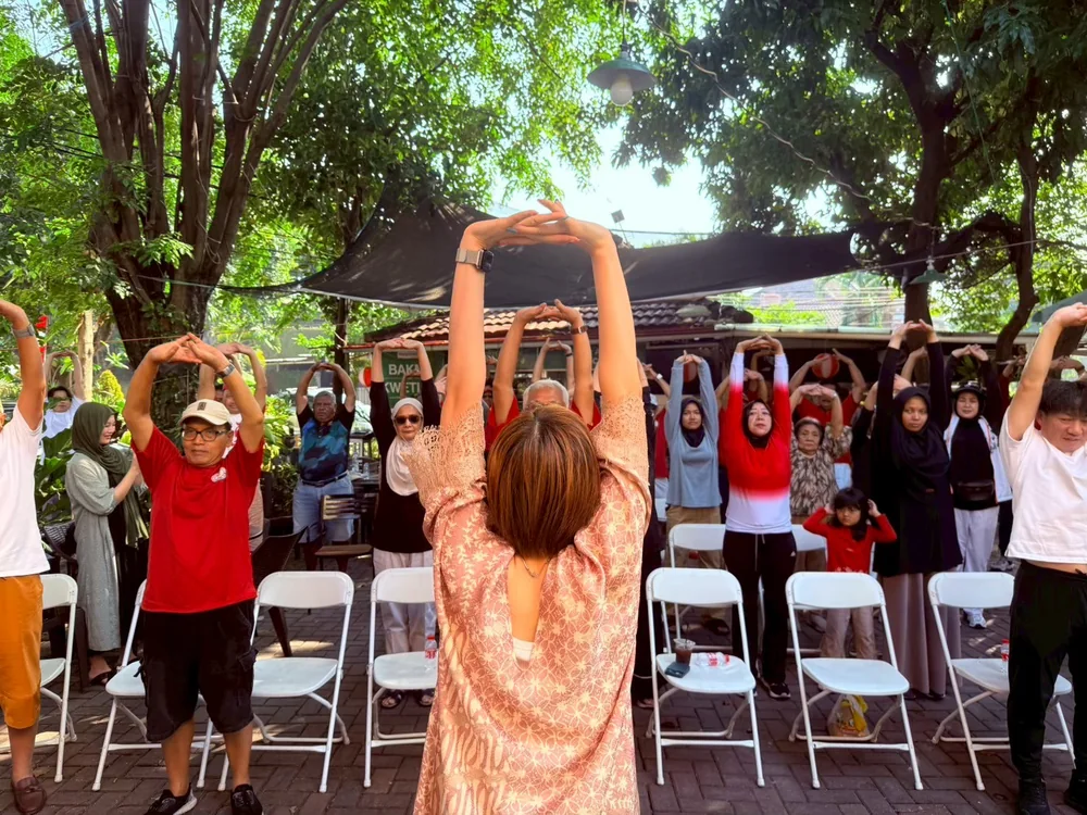 A visitor joining a community exercise session with local residents